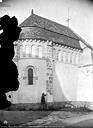 Beaulieu-sur-Layon : Eglise - Extérieur, choeur roman de l'ancienne église : côté nord-ouest, homme posant devant la façade