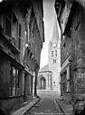 Montivilliers : Abbaye (ancienne) - Eglise : Clocher côté ouest, pris d'une rue bordée de vieilles maisons