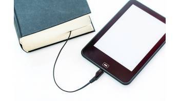 une liseuse reliée à un livre imprimé