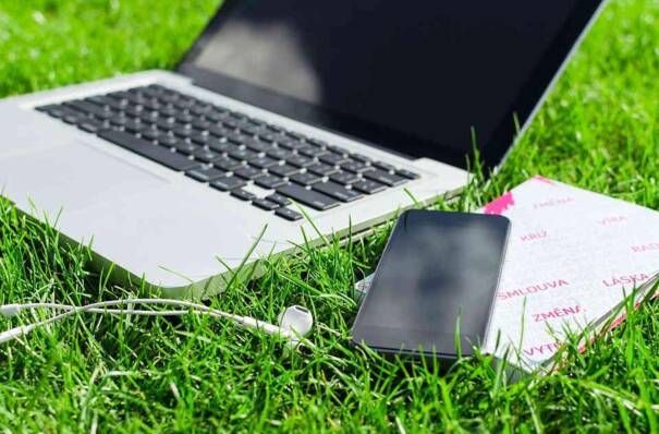 Un ordinateur et un téléphone posés sur une pelouse