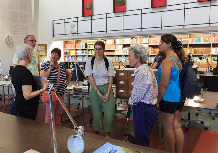 Les visiteurs et visiteuses écoutent la guide-conférencière des Archives départementales du Nord