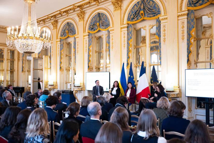 photo de quatre personnes sur une estrade en train de parler devant une foule