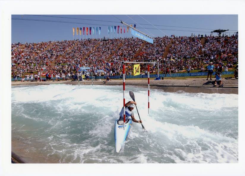 athlète en canoë kayak sur une rivière devant une foule aux jeux olympiques
