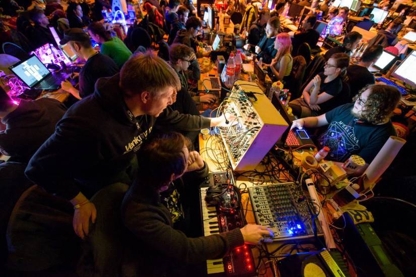 photo de personnes dans une salle devant des ordinateurs et des machines