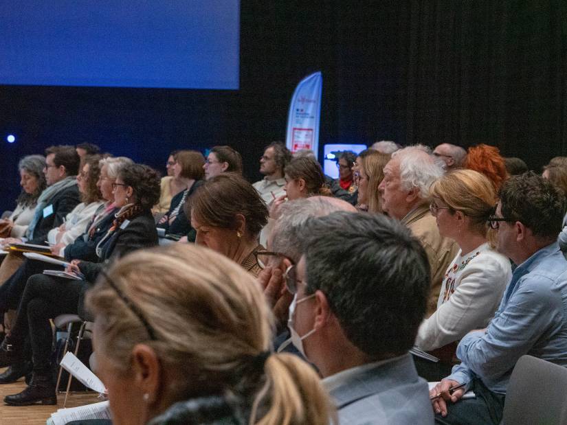 Photo 1 : de nombreuses personnes sont assises et semblent assister à une conférence