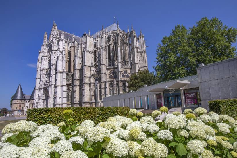 PHOTO 1 : La cathédrale de Beauvais est entourée de verdure et de fleurs blanches au premier plan.
