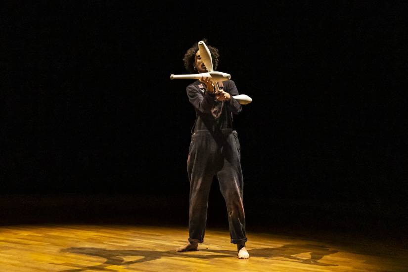 photo d'un homme sur une sc&egrave;ne en train de faire du jonglage avec des quilles