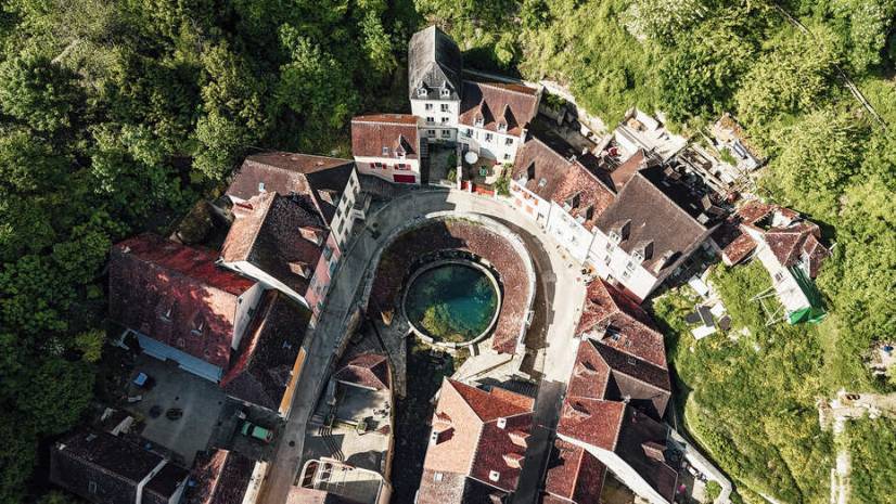 photo a&eacute;rienne d'une source am&eacute;nag&eacute;e en forme de cercle au milieu d'un village
