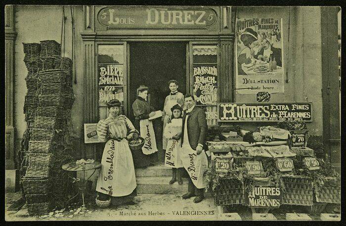 Photo ancienne d'un marchand d'huîtres et des commerçants qui posent devant la boutique.