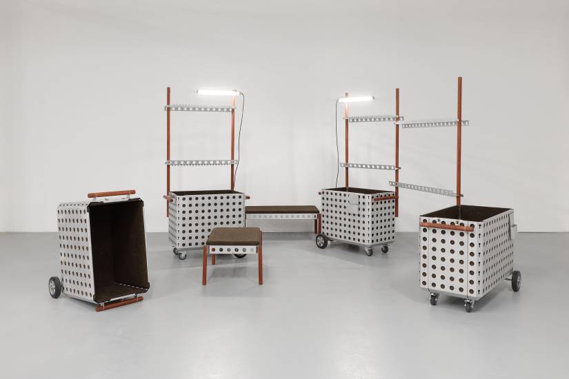 photo de plusieurs éléments en aluminium avec un chariot, des cimaises et des assises pris dans une pièce grise