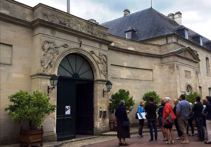 Une dizaine de visiteurs attendent devant la préfecture de l'Aisne, située dans l'ancienne abbaye Saint-Jean de Laon.
