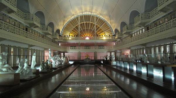 PHOTO 10 : Vue intérieure du musée La Piscine de Roubaix. Au centre de l’image, l’ancien bassin de la piscine est transformé en allée d’exposition, avec des statues tout autour.