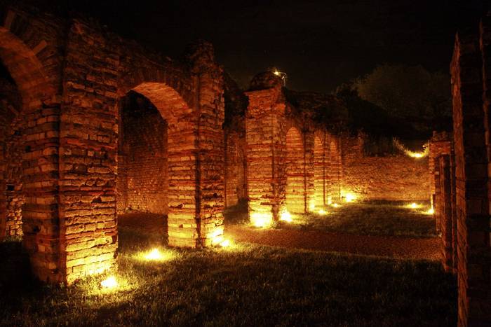 PHOTO 1 : Les ruines d'un bâtiment en pierre sont illuminées par des lumières jaunes au sol.