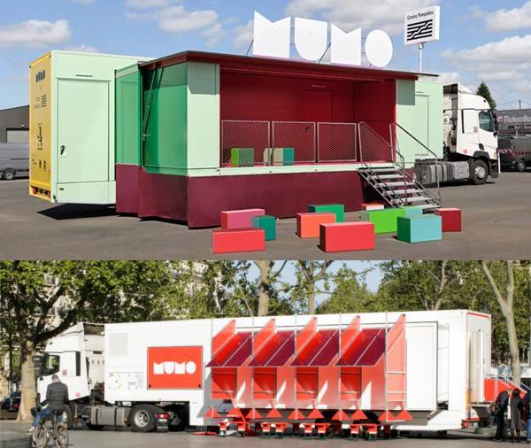 En haut de l'image se trouve le camion MuMo X Centre Pompidou de couleur verte garé sur un parking. Il est tourné vers la droite et déployé avec une scène rouge et verte surmontée des lettres M U M O, un escalier d'accès à la scène sur le côté droit, un panneau "Centre Pompidou" sur son toit et des cubes de couleurs devant pour s'asseoir. En bas de l'image, il y a le camion MuMo X Frac-Cnap de couleur blanche. Il est garé sur une place bordé d'arbres, tourné vers la gauche et est déployé avec des auvents et des tables rouges fixés au camion au-dessus de bancs rouges.