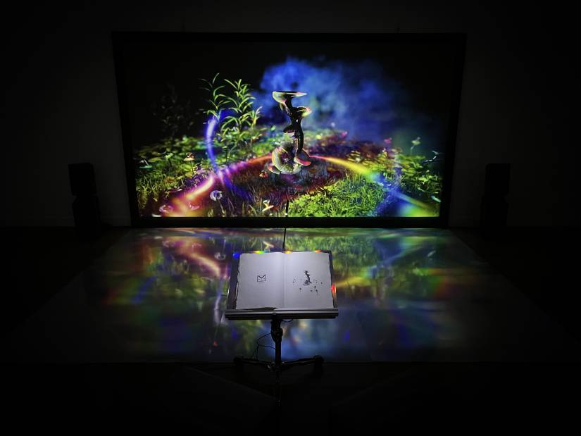 photo repr&eacute;sentant un dessin color&eacute; sur fond noir avec un livre ouvert au premier plan