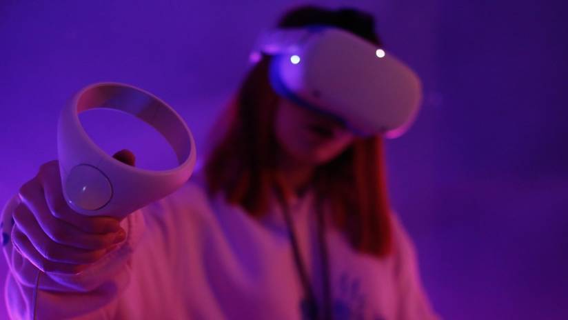 Une jeune femme avec un casque de réalité virtuelle et une manette