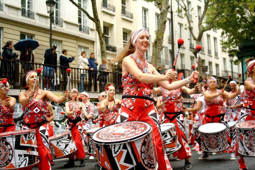 photo d'un groupe de percussionnistes brésiliens en train de jouer. Ils sont habillés en blanc rouge et noir