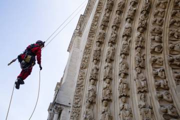 une personne descend en rappel le long de la façade de Notre-Dame