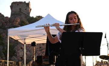 Jeune flûtiste avec tour gênoise en surplomb, en Corse