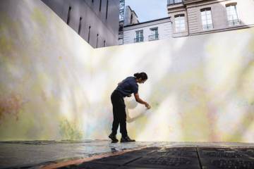 artiste_peint_fresque_immeuble_en_fond