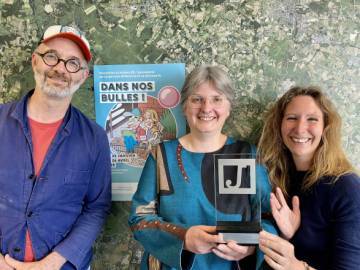 photo de trois personnes, deux femmes et un homme, tenant un troph&eacute;e