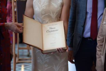 photo de quatre personnes dont une tenant un livre dans les mains ouvert à la première page