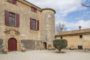 Photo du château de la Calade à Aix-en-Provence, château en pierre avec une cour avec un petit arbre