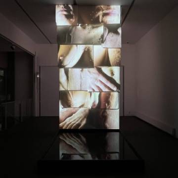 photo d'une oeuvre d'art compos&eacute;e d'une tour avec des &eacute;crans dans une pi&egrave;ce noire