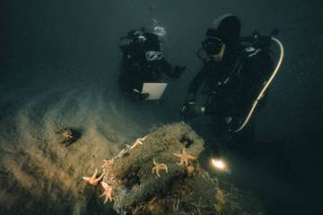 Photo de deux plongeurs autour d'un artefact