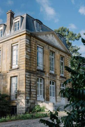 Photo de l'hôtel de Magny, maison en pierre entourée d'arbres