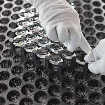 photo de mains avec des gants blancs sur une surface noire avec des alv&eacute;oles