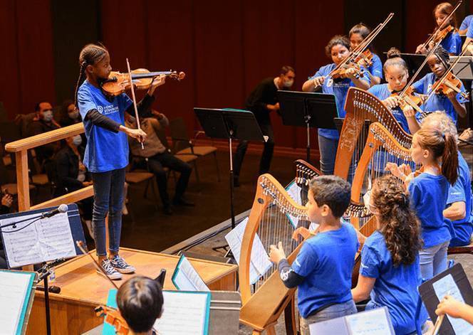 Jeune fille donnant le la avec son violon aux autres musiciens de l'orchestre de jeunes ados (Photographies : Philippe Stirnweiss pour Strasbourg eurométropole)