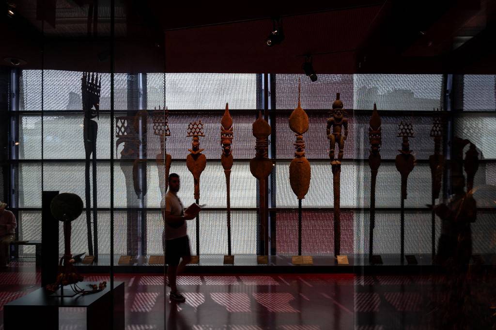 visiteur dans un musée avec des masques en contre jour