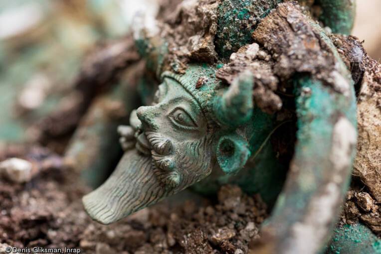 Anse d'un chaudron en bronze représentant la tête du dieu grec Acheloos provenant d'une tombe princière datée du début du Ve siècle avant notre ère, découverte dans un complexe funéraire monumental exceptionnel, mis au jour à Lavau (Aube), 2015. Vue aérienne d'un grand fossé ceinturant un tumulus princier Une  daté du début du Ve siècle avant notre ère, à Lavau (Aube), 2015 © Denis Gliksman, Inrap