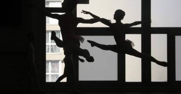 photo de danseurs classiques prise en contre jour dans un batiment moderne