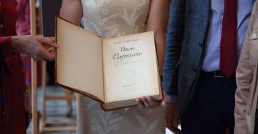 photo de quatre personnes dont une tenant un livre dans les mains ouvert à la première page