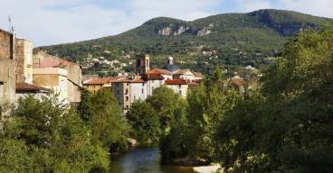 Photo prise à Lodève montrant au premier plan une rivière et au second la ville