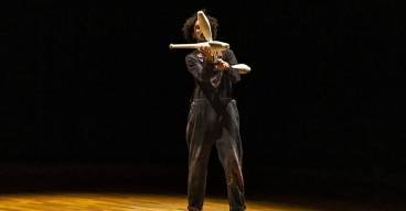 photo d'un homme sur une scène en train de faire du jonglage avec des quilles