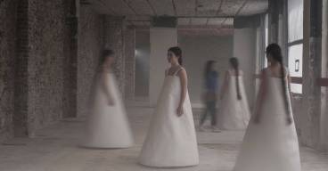 photo représentant 4 danseuses en robe blanche dans un décor industriel, image un peu floue