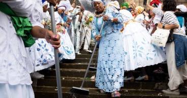 photo d'une dame habillée en blanc en train de balayer des marches d'escalier trempées