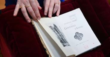 photo d'un livre ouvert avec une main qui le tient ouvert