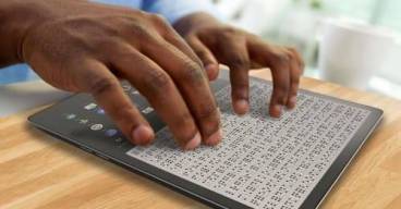photo d'une personne en train de lire du braille sur une tablette