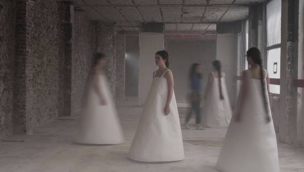 photo représentant 4 danseuses en robe blanche dans un décor industriel, image un peu floue