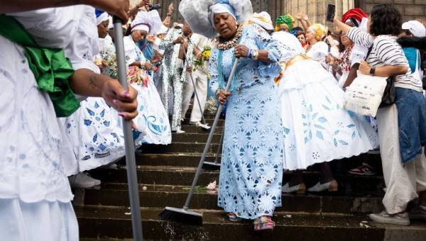 photo d'une dame habillée en blanc en train de balayer des marches d'escalier trempées