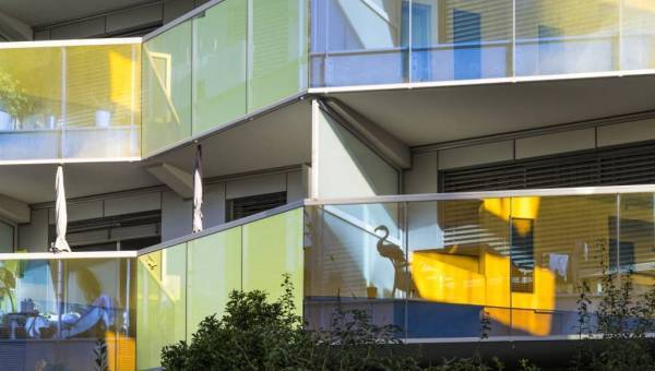 photo en gros plan de balcons d'un immeuble récent avec le reflet du soleil