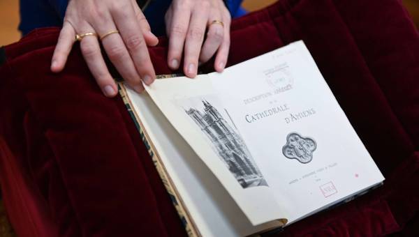 photo d'un livre ouvert avec une main qui le tient ouvert