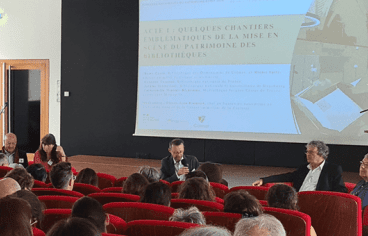 Photographie dans une salle de conférence avec cinq personnes menant une conférence
