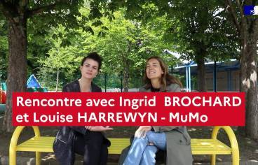 Visuel de l'épisode vidéo numéro 3. Le titre "Rencontre avec Ingrid BROCHARD et LouiseHARREWYN - MuMo" est placé au centre un peu vers le bas de l'image. En second plan sur un banc en métal jaune dans une cours d'école sont assises les deux intervenantes. En arrières plan, il y a des arbres, des jeux pour enfants à gauche et un préau donnant accès à des salles à droite.