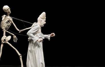 Marionnette qui représente un squelette derrière un comédien