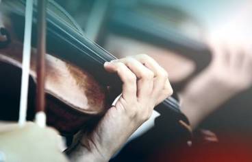 La photo de couverture est un gros plan de mains qui jouent du violon.